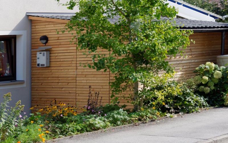 Abschließbare Fahrradgarage des Hotel Garni Möwe in Tutzing mit begrünter Außenanlage – sicherer Unterstand für Fahrräder und E-Bikes
